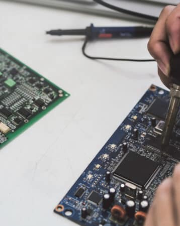 Close up of the hand men hold tool repairs electronics manufacturing Services, Manual Assembly Of Circuit Board Soldering.